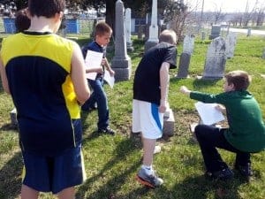 Students examine stones in the Big Run Cemetery.