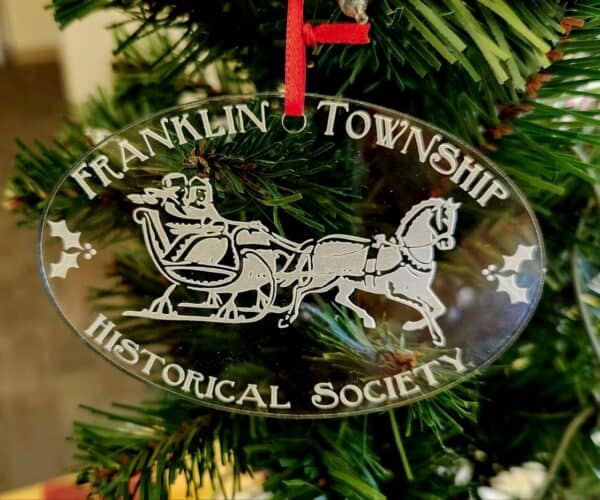 Christmas ornament featuring a horse-drawn sleigh
